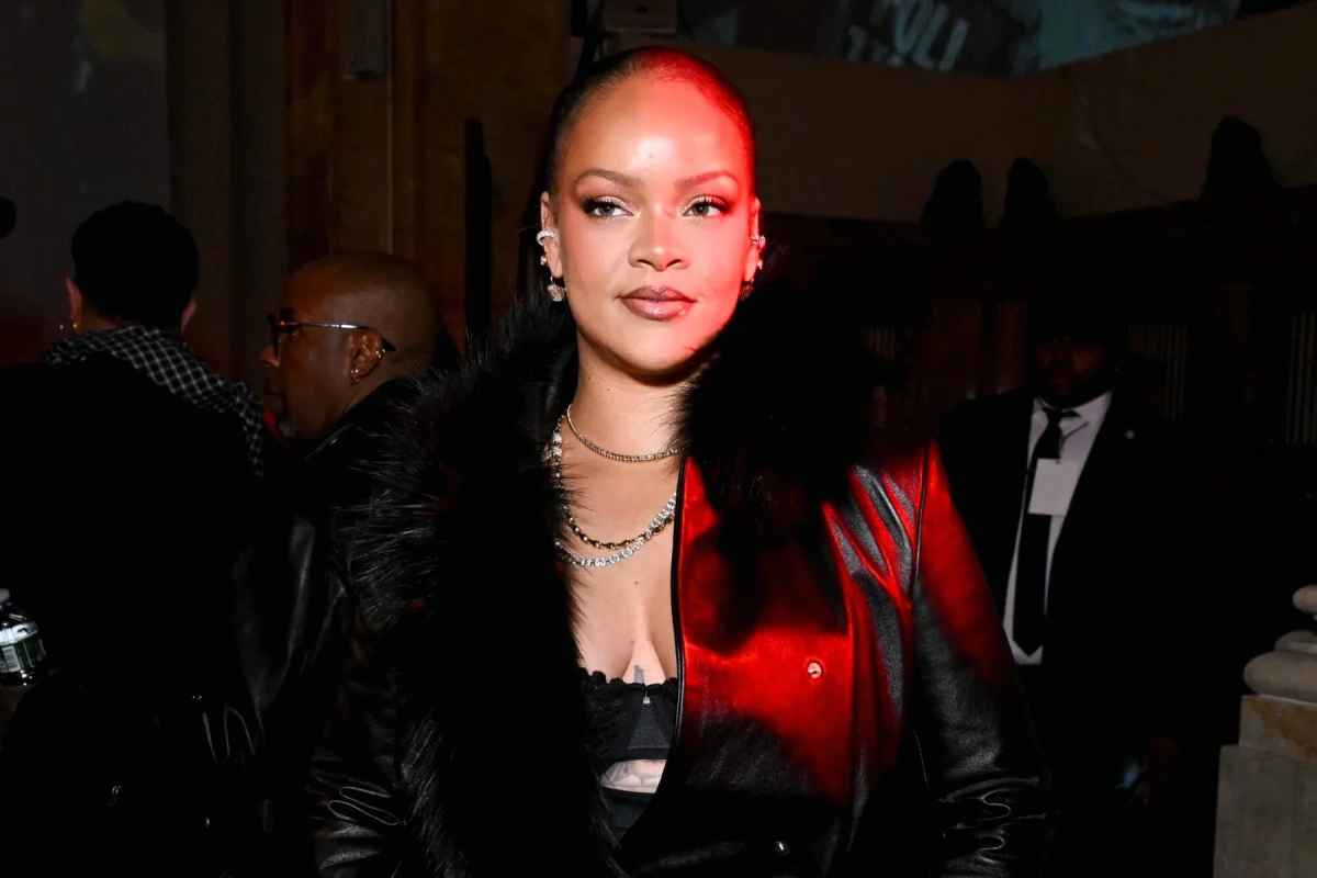 Rihanna tenant sa fille Rocki dans ses bras, souriante, dans une tenue décontractée en extérieur.