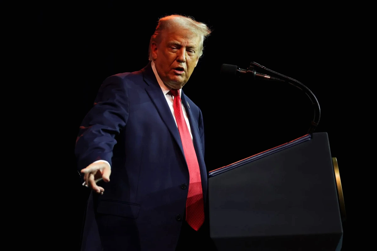 Donald Trump devant le Kennedy Center à Washington, avec le bâtiment en arrière-plan et des passants.