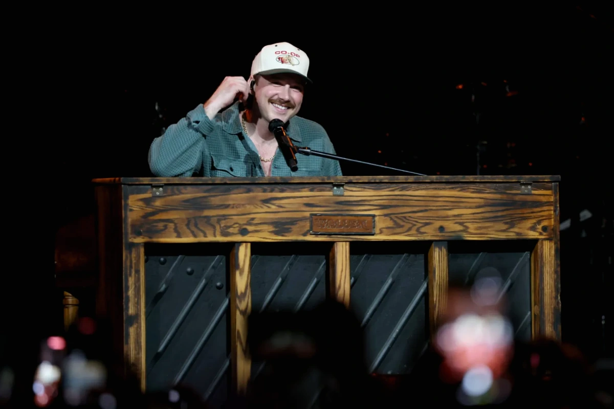 Morgan Wallen sur scène à Denver, renversant un piano noir sous les projecteurs, techniciens en arrière-plan