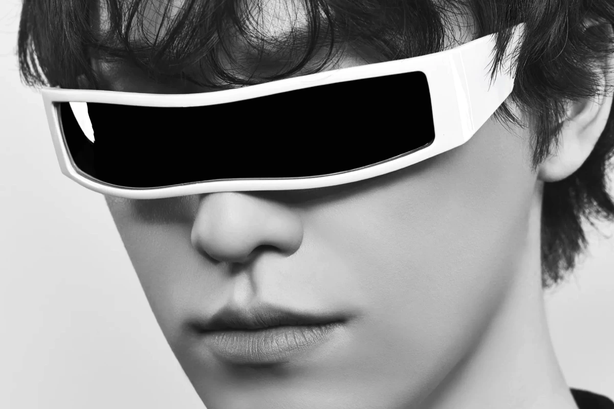 Portrait de DINO de SEVENTEEN en tenue sombre, regard vers l’objectif, fond neutre en studio.