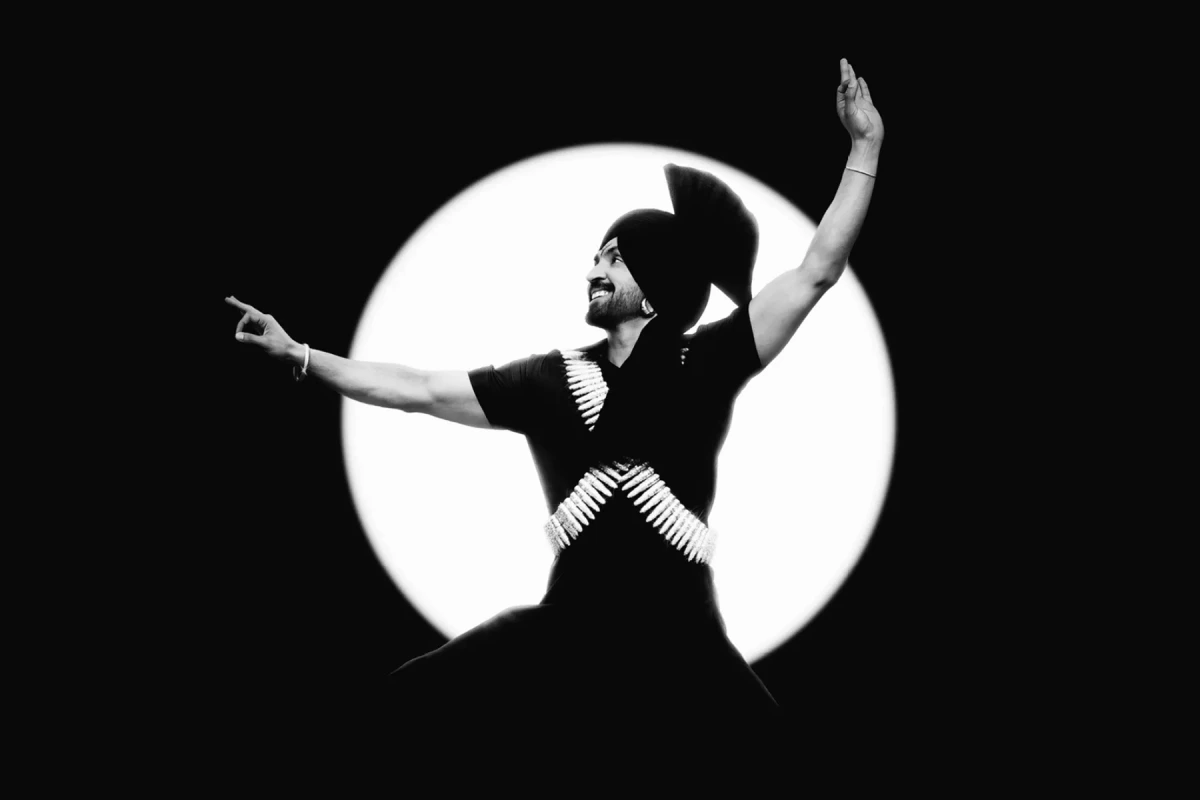 Diljit Dosanjh sur scène à Wembley, micro en main, devant une foule et des lumières de concert